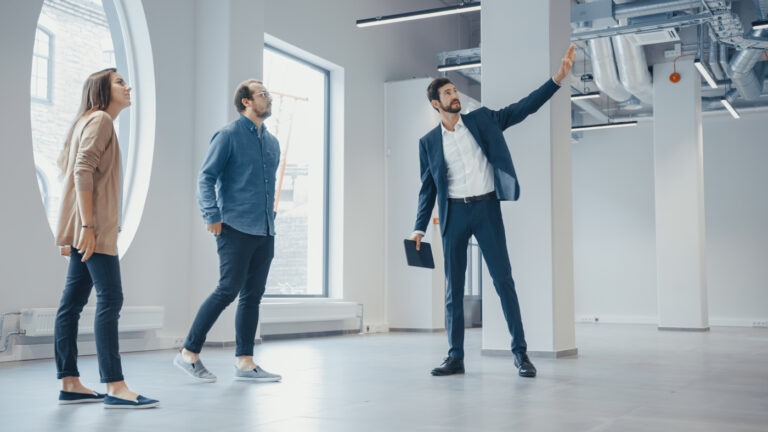 A real estate agent showing people around an office space