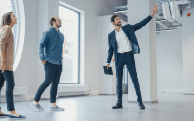 A real estate agent showing people around an office space
