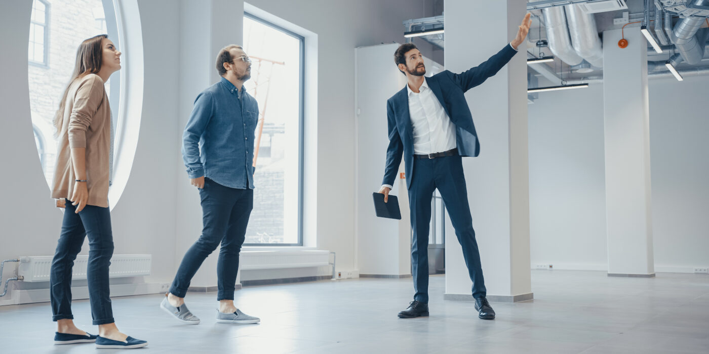 A real estate agent showing people around an office space