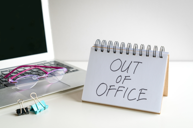A desk with a sign reading "Out of Office"